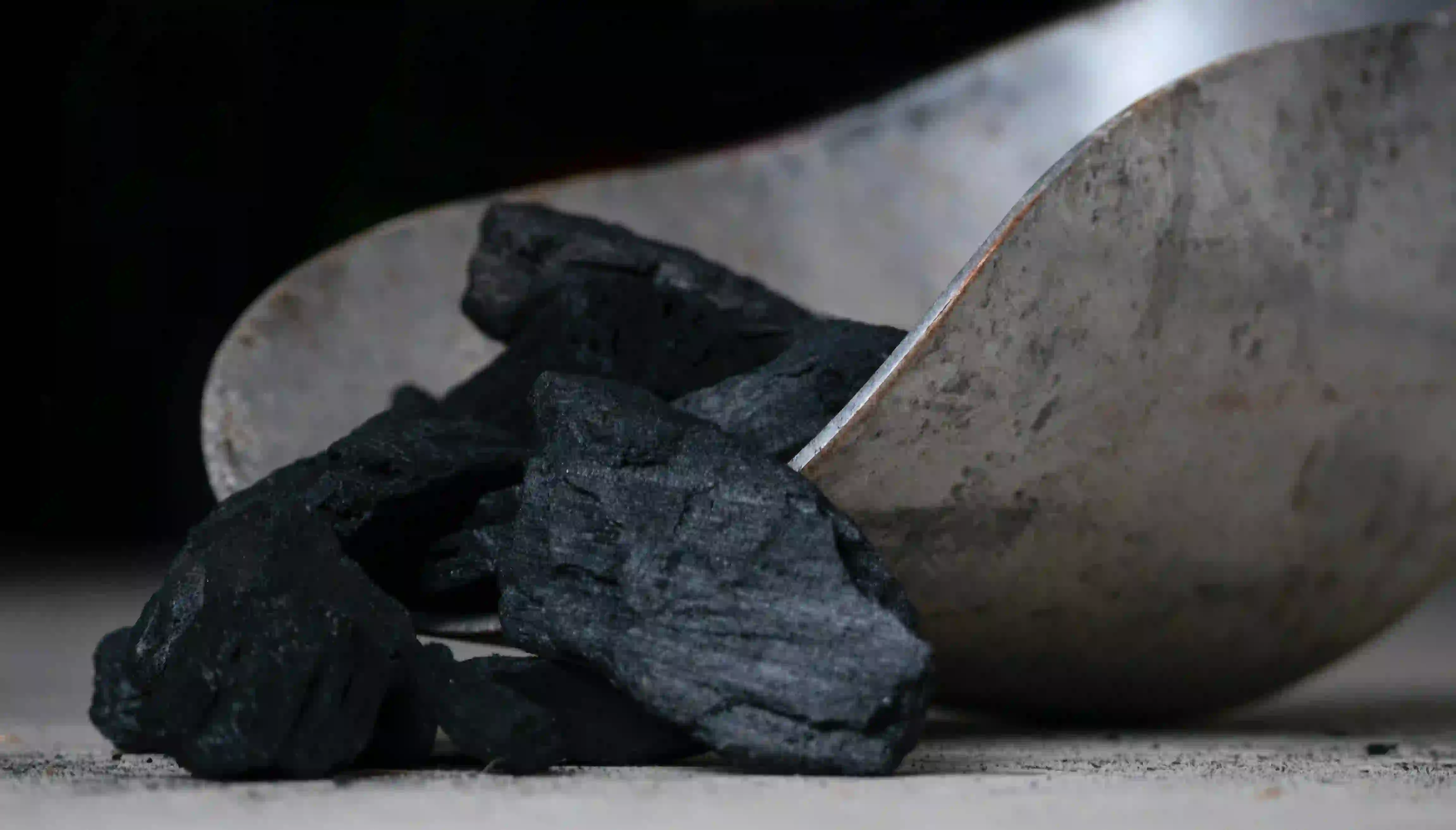 a batch of black coal bein picked up by a shovel